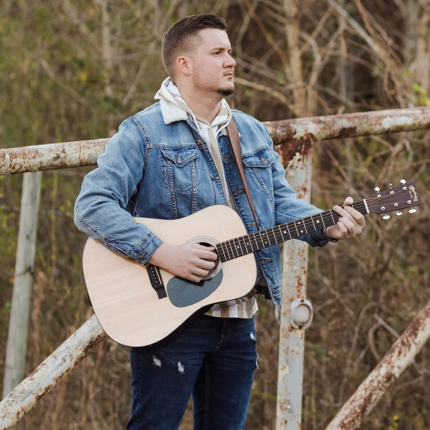 Daniel playing acoustic guitar outdoors